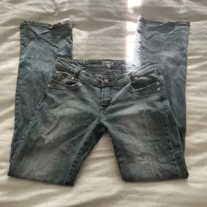 super söta vintage jeans med låg midja i en blå grå färg. de har silver nitar och broderi. liten skavning längst ner på den byxan inte inget för märkbart.