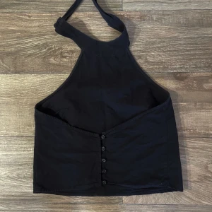 Svart halterneck topp m öppen rygg - Svart top med öppen rygg och knyte runt nacken. från NAKD x AFJ. Såå fin. Lite linnematerial. Är 164cm. Storlek M men ändå relativt liten.  Pris kan diskuteras vid snabb affär💓