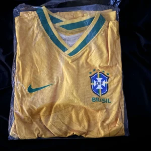 Fotbollströja - Custom Brasilien Shirt. Helt ny Brasilien fotbollströja med Nike logga. Skrynklig på bilden då den precis kommit från förpackningen, men vid strykning ska den bli slät.