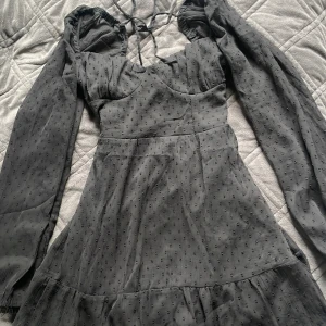 Svart klänning - En jätte söt svart lite kortare klänning från H&M’s Divided avdelning i storlek 38. Klänningen har en knytdetalj i ryggen och tunnare samt genomskinligt material på ärmarna. Klänningen är helt ny och aldrig använd, då den tyvärr inte passade mig. 🩷