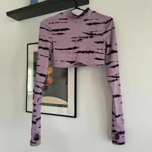 Långärmad croptop - Framkanten formar sig lite efter brösten. Finns även hål för tummarna.   Katt finns i hemmet! 