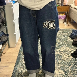 vintage D12 byxor - riktigt feta baggy jeans!!! väldigt sällsynta D12 byxor, alltså eminems gamla band. lite slitna längst ner vid fötterna men annars inga skador. jag är 166 för referens! 