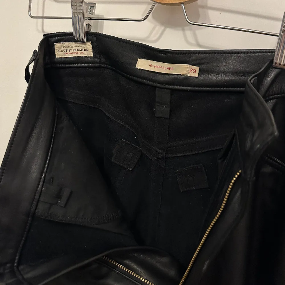 Svart byxa i skinnimitation från Levi’s i storlek 29/32.  Modellen heter ”70s high flare” Använda ett fåtal gånger, i väldigt gott skick . Jeans & Byxor.