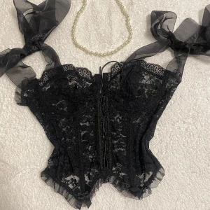 Korsett topp - SUPER SNYGG korsett topp<3 man knyter fina rosetter vid axlarna för att justera storleken. Den är stretchig och har snörning i mitten.🤍 OBS accessoarerna ingår EJ(halsband)🤍