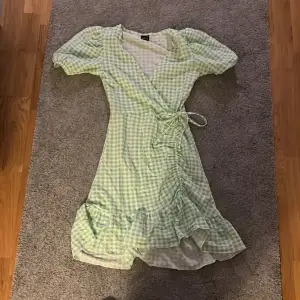 Grön rutig klänning från Gina tricot i xs har aldrig använt med ballong armar och med en liten rosett vid sidan det är volanger längst ner och den är urringad!❤️