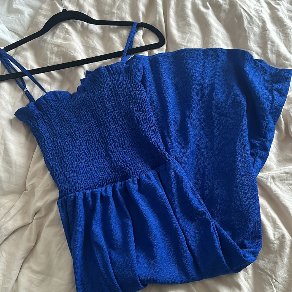Blå sommarklänning från H&M. Endast använd 1 gång (bild 2 är lånad). Justerbara axelband och resår över bröstet. . Klänningar.