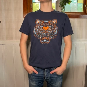 Kenzo T-shirt  - Marinblå kenzo t-shirt | Skick 9/10| Storlek M | Pris: 99kr | Modellen är 175 cm | Fraktar via PostNord och Instabox på köparens bekostnad:)  Hör av dig vid frågor och funderingar mvh 