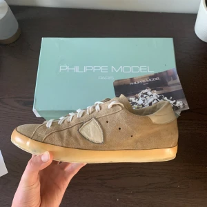Philippe Model Skor - Beigea philippe model skor i ganska bra skick. Originalbox ingår och lappen som syns i första bild. Ena sulan har gått sönder en del. Sitter normalt i storlek. 