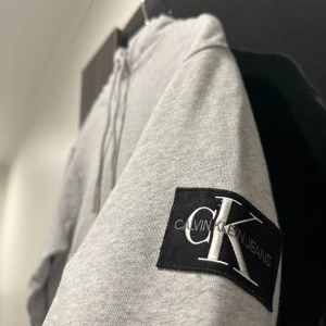 Ck hoodie  - Ck hoodie i färgen grå, jätte snygg och trendig! Cond:8,5/10. Tveka inte vid frågor, köparen står för frakt📦