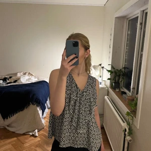Mönstrad topp med volang - En jättefin top med volang och knytning i nacken. I nyskick, säljer pga ingen användning://