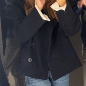 Kappa från Gina tricot  - Säljer en jätte fin mörk blå kappa från Gina young. Den är jätte fin och har en ficka på varsin sida. Jag säljer denna eftersom den är lite för liten och ska köpa ny. Den är i bra skick och har används någr gånger. Jag tvättar den innan den skickas.