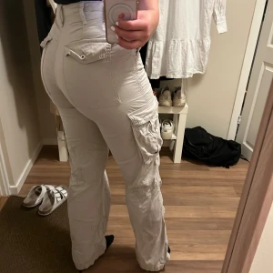 Cargopants - Sjukt snygga cargobyxor i en grå/beige färg från Bershka. Sparsamt använda så i väldigt bra skick! Tightare modell, säljes på grund av för små för mig.