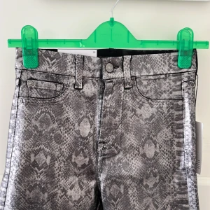 7 for all mankind snakeskin byxor - Helt nya byxor från 7 for all mankind i storlek W25. Passar XS tänker jag. Har ett fräckt snakeskin mönster och skimrar i silverfärg. Är rätt stretchiga och i perfekt nyskick, lapp sitter kvar. 