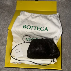 Bottega Veneta mini pouch  - Intressekoll på min älskade bottega väska. Köpt på mytheresa nypris 25520kr säljer för runt 15000 vilket var priset jag köpte den för då. Färgen är mörk brun och finns inte kvar längre. Lite sliten i färgen i öppningen då den stängs av metaller