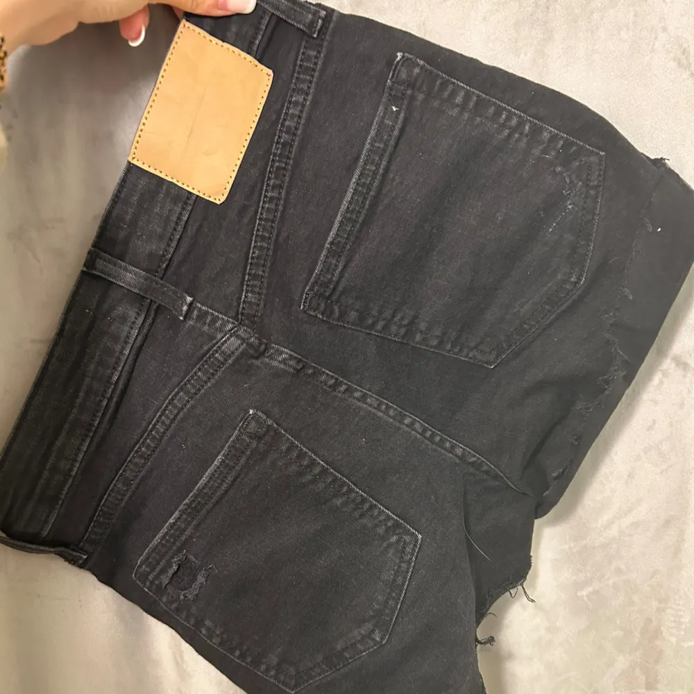 Svarta/mörkgrå jeansshorts från H&M i storlek 36/S. Sliten design och medelhög midja. Gott skick, använda ett fåtal gånger!. Shorts.