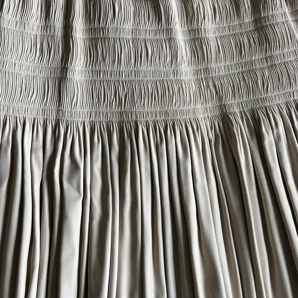 En beige räfflad skinn kjol från Zara i storlek XS, men funkar även för S. Använd endast en gång och är i bra skick. . Kjolar.