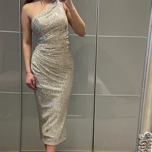 Festklänning - Storlek S. Använd 1 timme. Precis som ny. Färgen skimrar mer åt det beigea/champagne färgade hållet i verkligheten.  Väldigt stretchig och kan passa en större storlek. 