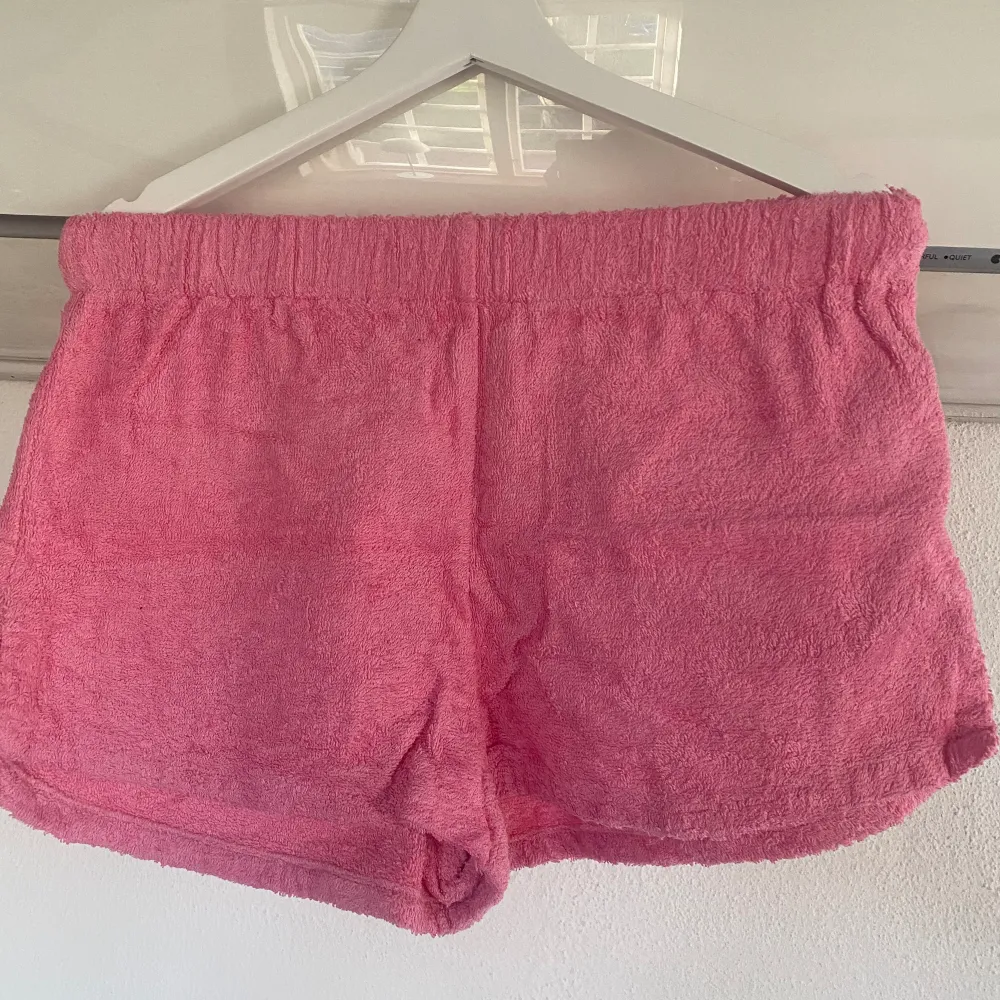 Rosa shorts i frotté från Nelly.com (Terry Beach Set) med resår i midjan. Använda 1 gång, som nya. Nypris för hela setet: 599 kronor.. Shorts.