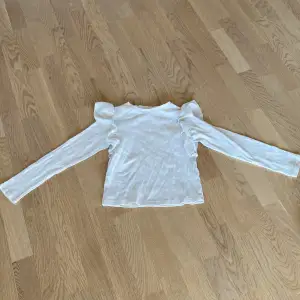Vit tröja med volang på sidorna i barn size
