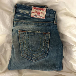 True Religion Jeans - Assnygga lågmidjade straight True Religion jeans med röd och gul söm. Säljer pga för små för mig. Pris går att diskutera. Skriv privat vid frågor. Midjemått är 35 och innerbenslängd är ca 76💟