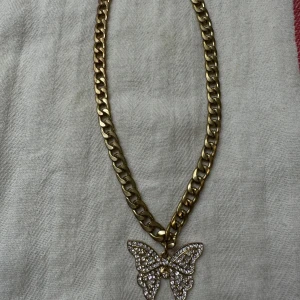 Halsband  - Det är en guld halsband med diamanter den har en fjäril, det är inte riktig guld inte heller diamanterna, den är jätte fin, har inte använt den men har haft den i en låta så gulden har blivit lite rostig, men Det märks knappt.
