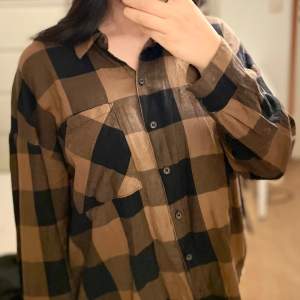 Oanvänd brun/svart skjorta