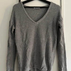 Stickad tröja - Superfin grå stickad tröja med v-ringning. Köpt på na-kd i storlek xxs men skulle gissa att den kan vara xxs-s beroende på hur man vill den ska sitta. Bra skick.