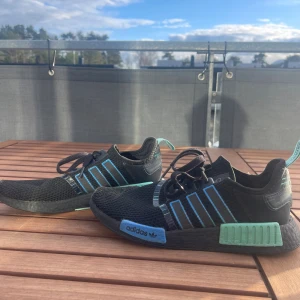 Adidas Nmd - Säljer nu dessa Adidas nmd i svart färg med blå och turkosa detaljer. Skicket är som nyskick, de är använda få gånger. Finns inga defekter och knappast så att sulan ser använd ut. Priset går att diskutera.
