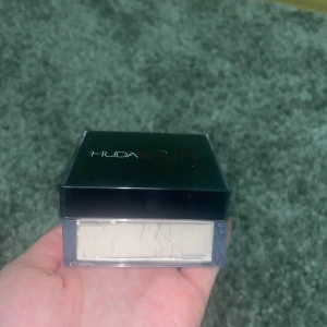 Huda beauty powder  - Säljer denna Huda Beauty powder i färgen pound cake. Produkten var använd få tal gånger men skulle säga de finns 95% kvar. Den är fylld hela vägen. Skriv om ni vill ha flera bilder på den! 