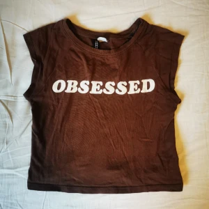 Topp med tryck!  - Jättesnygg baby tee med texten "obsessed", använd men i gott skick. Den är i storlek xxs men passar även xs. Skriv för mer info💖