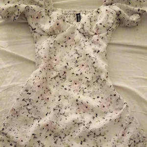 Vit blommig klänning! - Storlek XXS (passar XS), jätte fin vit klänning med blommor, puffiga armar och en fin sweetheart neckline. Den är tight vid midjan så ger fina kurvor. Köpte för 360 kr men priset kan diskuteras.❤