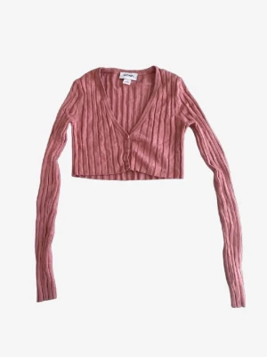 Rosa croppad kofta i storlek s - Säljer en rosa croppad kofta med lång ärm. Djup V-ringning och knäppning framtill ger en snygg siluett. Perfekt att styla över ett linne eller topp för en cool look. Koftan är i storlek S och den är ifrån monki. Det finns tecken på användning men inget som syns.