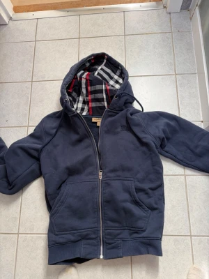 Mörkblå burberry hoodie - Säljer nu min burberry hoddie för den blivit för liten storleken är s och den passar som bäst om man är 170 med tanke på att det är snyggare när den är lite tajtare. Priset kan diskuteras!
