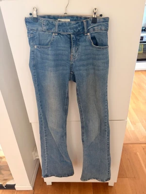 Gina tricot perfekt jeans  - Säljer ett par klassiska blå bootcut jeans med ljus tvätt, som inte längre kommer till användning💘 skriv för fler bilder 