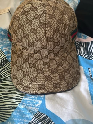 Beige keps med GG-mönster  - Oanvänd vill bli av med den