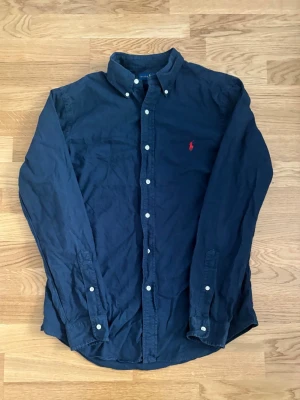 Mörkblå Ralph Lauren skjorta - Otroligt fräsch mörkblå skjorta från Ralph Lauren i slim fit. Skjortan har långa ärmar och knappar framtill. Skriv vid minsta fråga!🙌