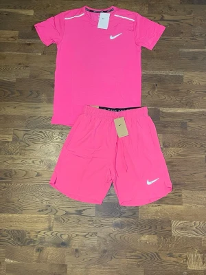 Rosa träningsset  - Säljer ett sportigt träningsset f i stark rosa färg. Setet består av en kortärmad t-shirt och matchande shorts