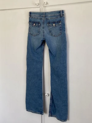 Blå bootcut low waist jeans från gina  - Snygga blå bootcut jeans med låg midja och klassiska fem fickor. Jeansen har en lätt tvättad look. Perfekta för en avslappnad och trendig stil. Materialet är denim i bomull. Mycket bra skick!💞