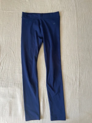 Mörkblå leggings i stretchmaterial - Mörkblå leggings med hög midja och smal passform. Tillverkade i ett mjukt och stretchigt material som ger bra rörelsefrihet. Perfekta för träning eller chill. Enkel design utan fickor eller synliga detaljer.