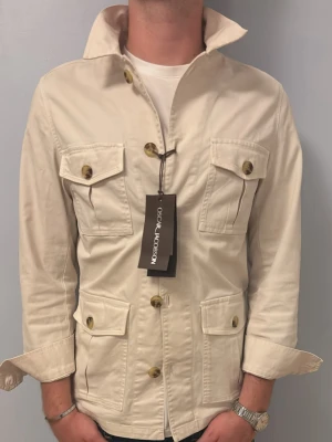 HELT NY Oscar Jacobsson overshirt beige - HELT NY Oscar Jacobsson Safari jacka | Skick: 10/10 (helt ny med prislapp, inga tecken på användning) | Storlek: M, passar dig som är runt 180-185cm | NYPRIS: 2499kr!! | Fraktar inom 24H efter köp📦 Hör av dig vid minsta fråga eller fundering🌟