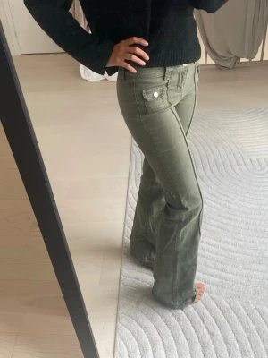 Gröna HM jeans - Snygga Jeans från HM. Byxorna har en avslappnad passform och stängs med knapp och dragkedja. Perfekta för en trendig och avslappnad stil.