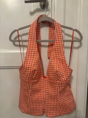 Ny Zara topp - Säljer en superfin röd och vit rutig halterneck topp med djup urringning och smala axelband. Toppen har en figurnära passform och knyts i nacken. Perfekt för sommarens alla tillfällen!