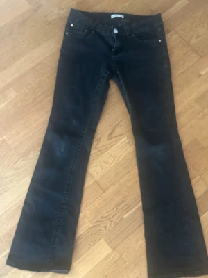 Svarta bootcut jeans🖤 - Säljer ett par svarta bootcut jeans från Gina triccot i storlek 40 (samma som M) med låg midja och lock på fickorna. De har en bra passform och är lätt utsvängda där nere.