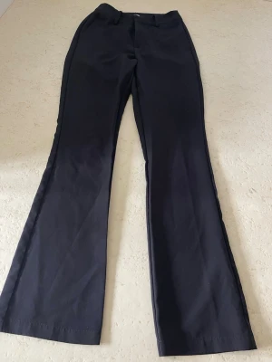 Svarta kostymbyxor från BikBok - Säljer ett par svarta bootcut kostymbyxor från BikBok i storlek 34. Midwaist, perfekt för en clean och stilren look.