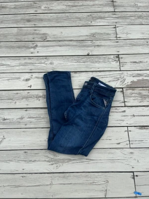 Mörkblå jeans från Replay - Snygga mörkblå jeans från Replay med klassisk femficksmodell och kontrastsömmar. Jeansen har normal midja och raka ben. Materialet är denim med en mjuk känsla och stretch för extra komfort. Perfekta för en avslappnad och trendig stil.