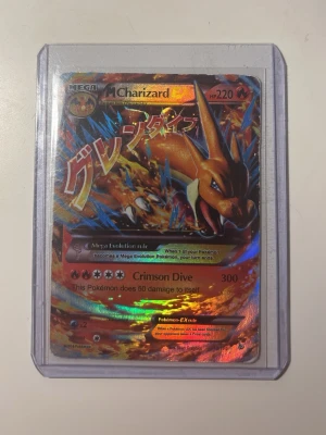 Pokémonkort Mega Charizard EX - Säljer ett Pokémonkort med Mega Charizard EX motiv. Kortet har en färgstark och holografisk design med japansk text och ligger i ett genomskinligt plastfodral. Perfekt för samlare eller Pokémonfans.