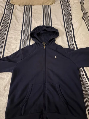 Mörkblå hoodie från Polo Ralph Lauren - Hej, säljer nu denna Ralph lauren hoodien.   Inga defekter och endast använd fåtal gånger. Original pris ~1200. Priset är inte hugget i sten. Skriv om ni undrar något!