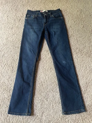 Mörkblå slim levis jeans - Snygga mörkblå jeans med slimt passform och klassisk femficksdesign. Jeansen har normal midja och är tillverkade i ett mjukt denimtyg som ger en bekväm känsla. Perfekta för dig som gillar en tidlös och avslappnad stil modell 512.