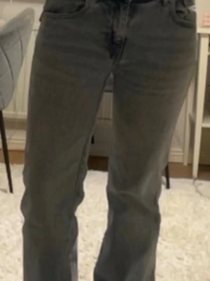 Ljusblå raka jeans - Säljer ett par ljusblå jeans med rak/bootcut passform. Jeansen har klassiska fem fickor och bälteshällor. Materialet är denim i bomull och färgen är tvättad grå, vilket ger en cool vintagekänsla. Perfekta till en avslappnad stil. Bakfickorna går att stänga.