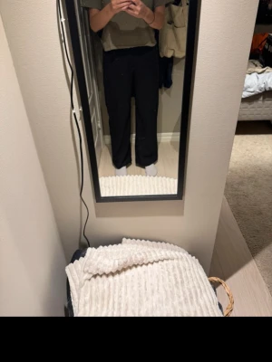 Svarta raka kostymbyxor - Säljer ett par svarta kostymbyxor med rak passform och hög midja. Byxorna har en clean look och är tillverkade i ett slätt tyg som ger en snygg siluett. Perfekta för dig som gillar stilrena och enkla plagg.